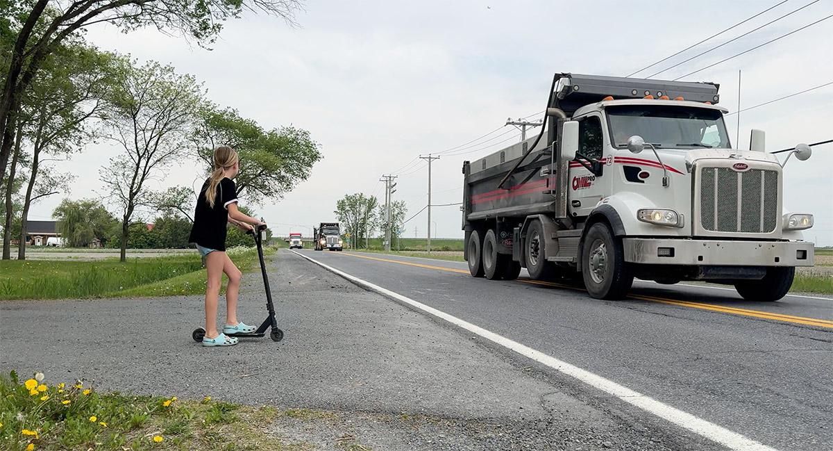 Enfant sur Chemin de la Butte-aux-Renards qui attend que les camions passent
